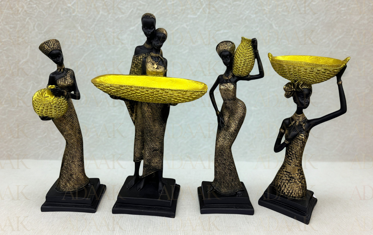 Set of four decorative statues of women holding baskets on a light gray background