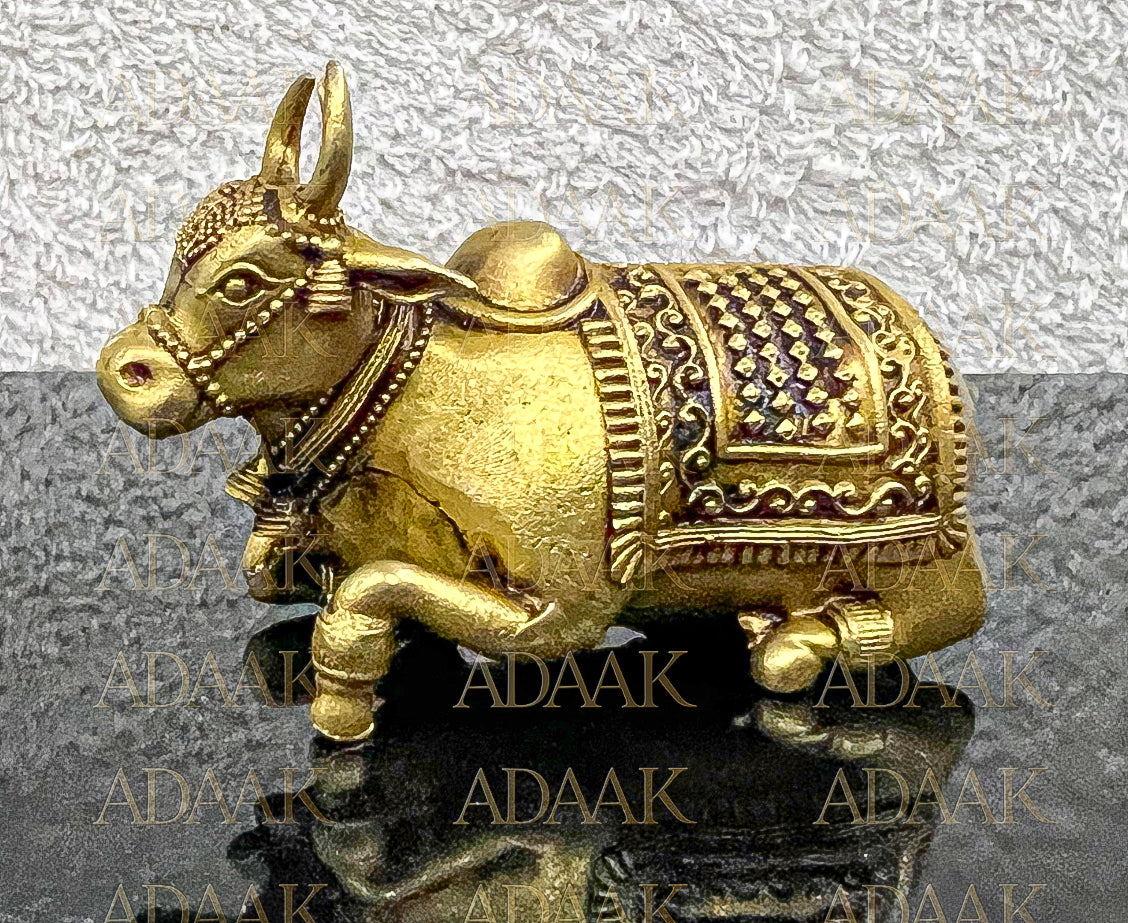 Decorative Brass Nandi on a reflective surface with 'ADAAK' branding.