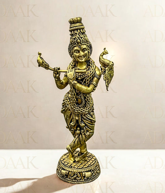 Brass statue of a deity holding a flute peacock on a white background