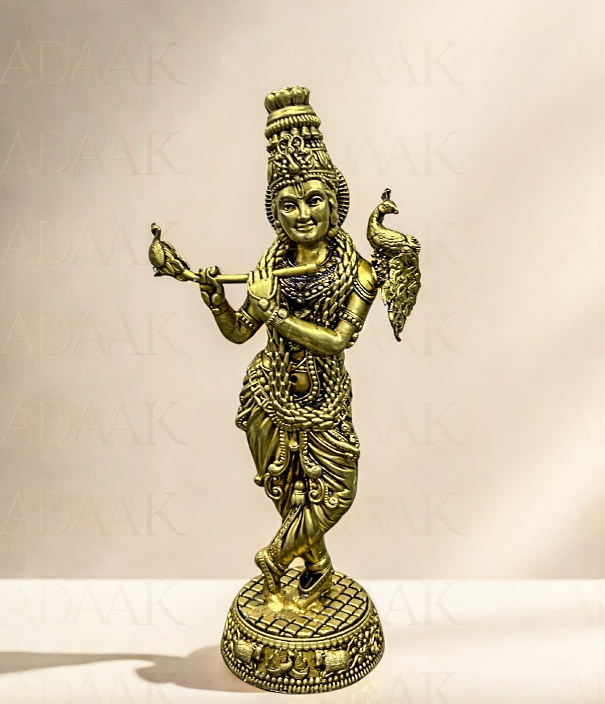 Brass statue of a deity holding a peacock on a beige background