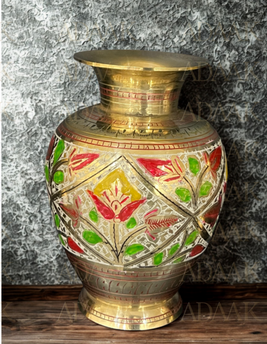 Decorative brass vase with floral patterns on a textured surface