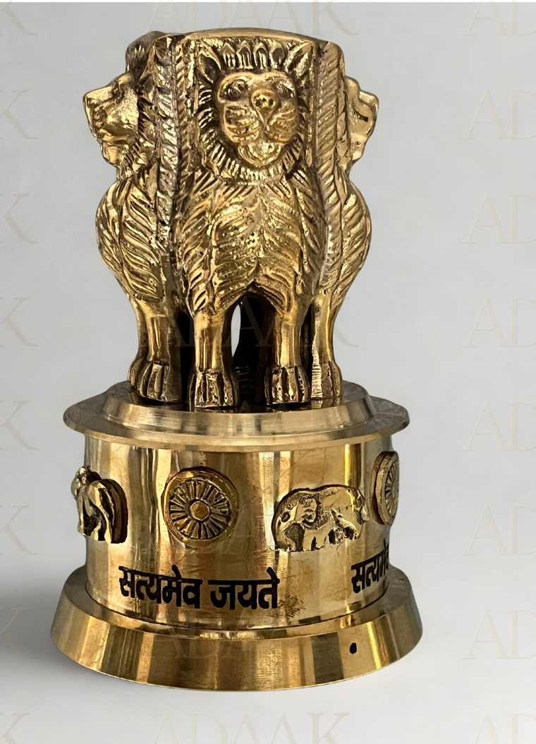 Brass lion statue on a cylindrical base with engravings on a white background