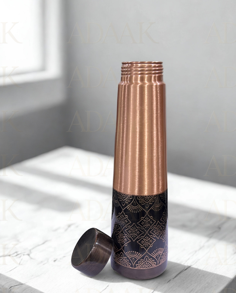 Copper and black patterned water bottle on a light surface with a neutral background