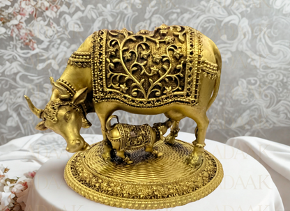 kamdhenu cow with calf with intricate designs on a white surface.