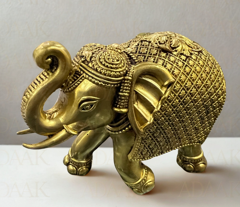 Decorative Brass elephant figurine on a white surface with a light gray background