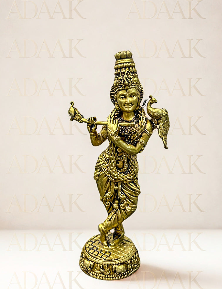 Brass statue of a deity with intricate details on a light background