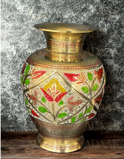 Decorative brass vase with floral patterns on a textured surface