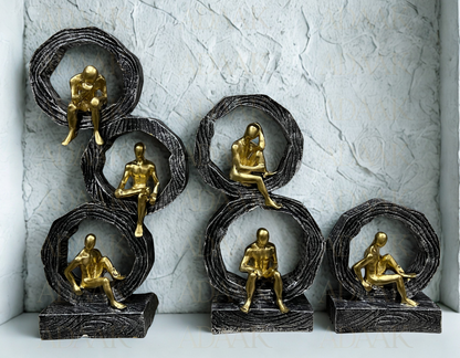 Set of six gold and bronze figurines on textured gray background