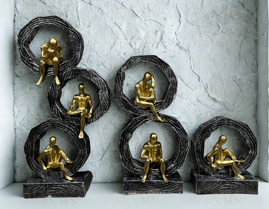 Set of six gold and bronze figurines on textured gray background